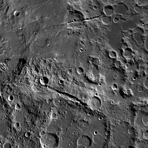 A grayscale image captures the moon's surface, featuring numerous craters of varying sizes. The scene is reminiscent of a lunar Grand Canyon, with a highlighted spot drawing the viewer's attention.