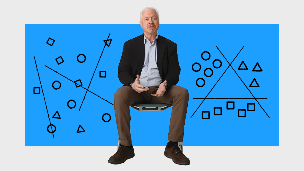 A person sits on a stool against a blue background with black and white geometric diagrams, including lines, circles, squares, and triangles.