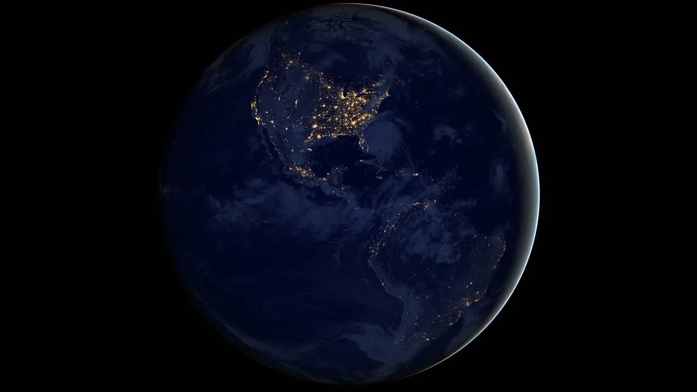 From the vastness of space, Earth at night reveals its exo-earth beauty, with illuminated continents showcasing a tapestry of lights across North and South America. Major cities and regions emerge from the glowing darkness, painting a vivid picture against the backdrop of oceans.