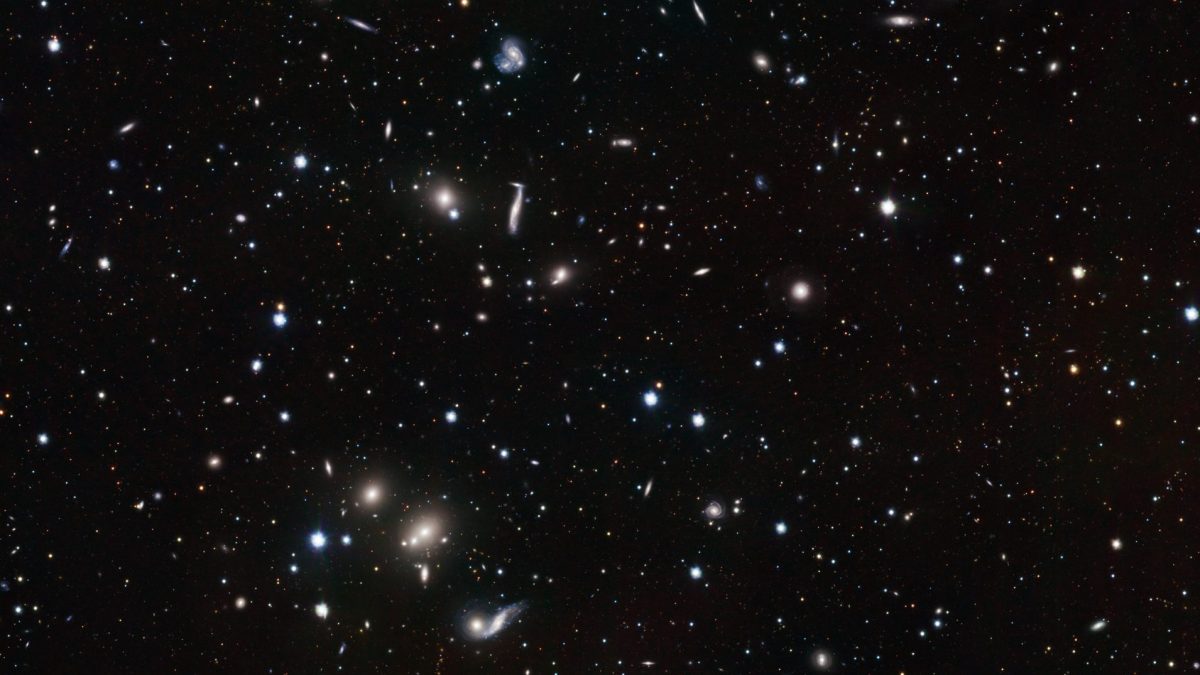 A vast starry sky showcases a spinning galaxy, a relic from 12 billion years ago, among countless stars of varying brightness on a dark background.