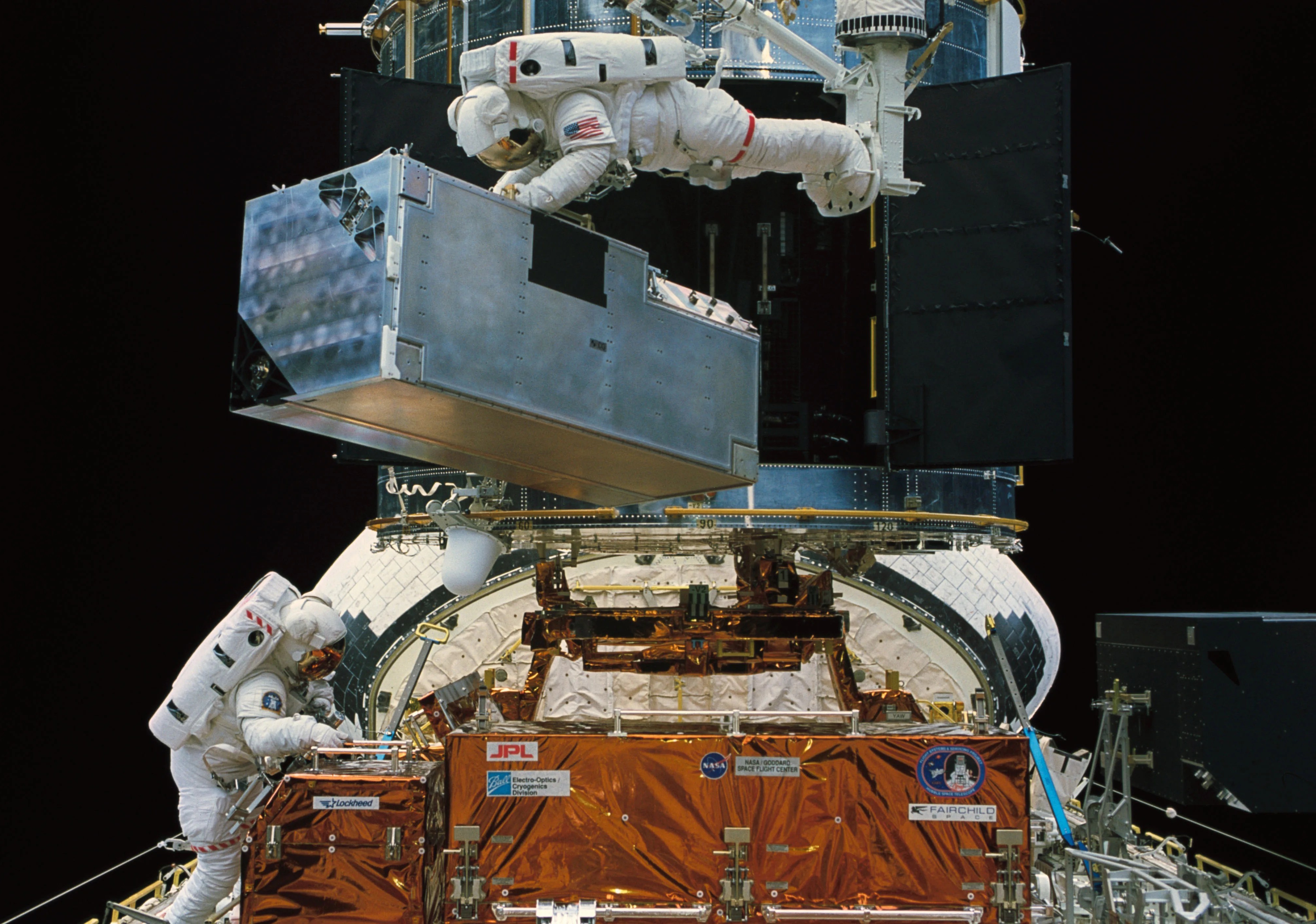 Two astronauts conduct maintenance on a space telescope in orbit, surrounded by cutting-edge technology and machinery. This mission supports NASA's quest to capture the most important images in history, all set against the breathtaking backdrop of the cosmos.