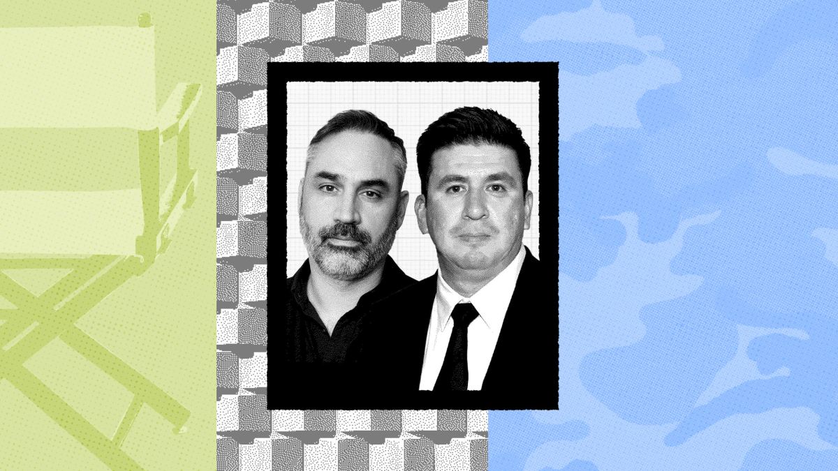 Two men pose for a formal portrait; one wears a dark shirt and the other a suit and tie, set against a patterned background evocative of Alex Garland’s visual style, divided into green, gray, and blue sections.