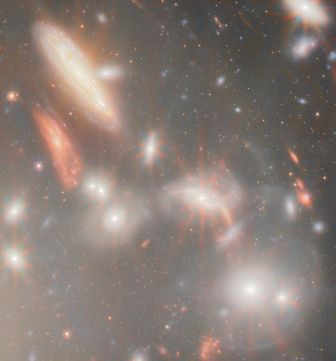 An image showing a cluster of glowing galaxies and bright stars scattered across a dark background in deep space, captured by JWST, revealing the most extreme gravitational lens effects ever observed.
