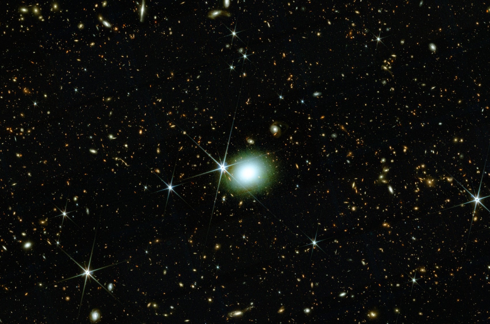 A bright elliptical galaxy is centered among numerous stars and distant galaxies in a dense star field, showcasing the wonders revealed by JWST science in deep space.