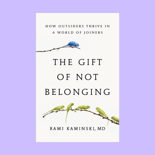 Book cover of "The Gift of Not Belonging" by Rami Kaminski, featuring one blue chameleon—an Otrovert—on a branch above five green chameleons on a branch below.