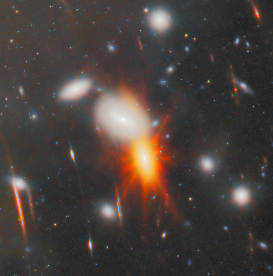 A bright orange-red galaxy cluster with glowing light at the center, surrounded by smaller, blurry stars and galaxies in deep space&mdash;one of the JWST's most extreme gravitational lens discoveries.