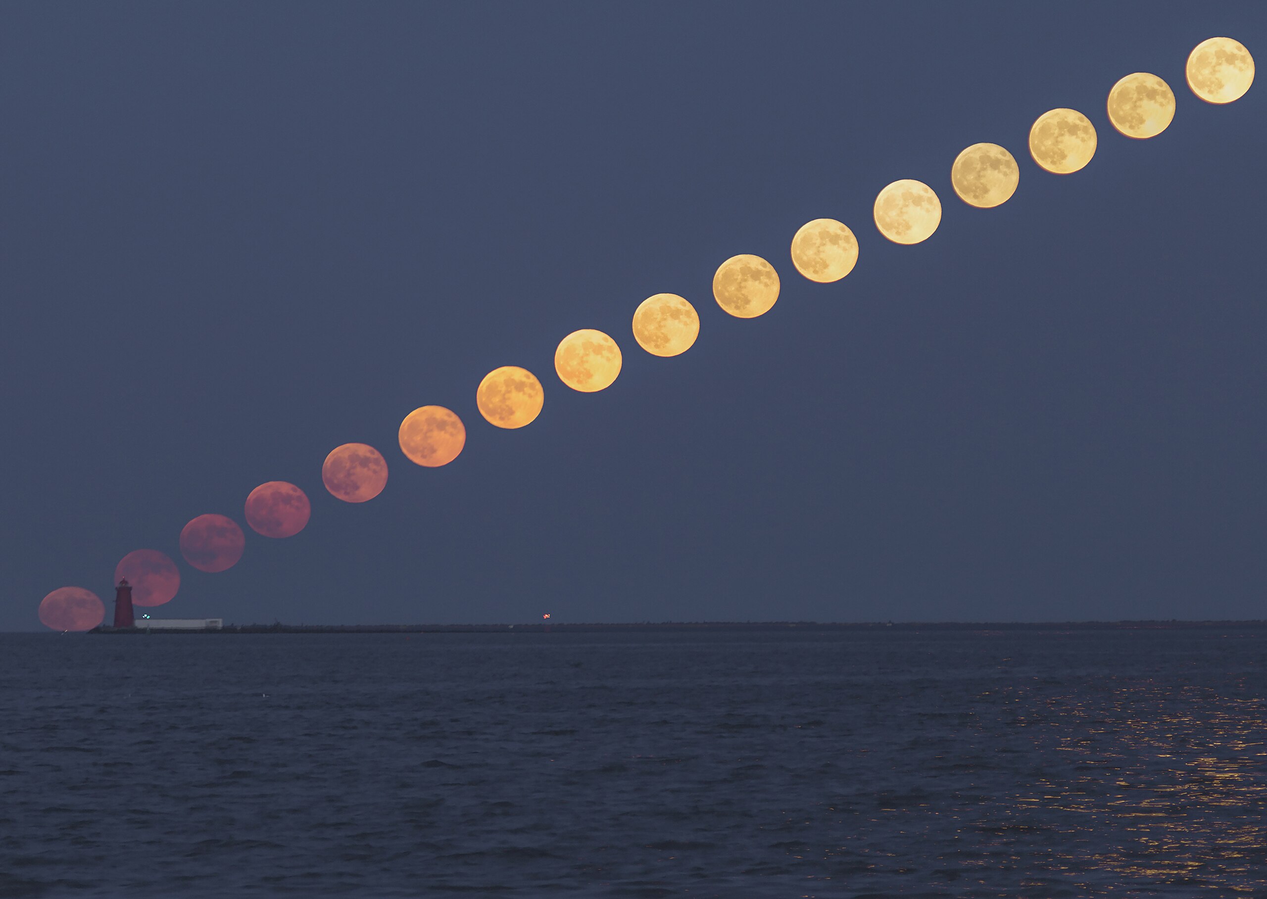 A composite image showing the sequence of a full moon rising diagonally over a lighthouse by the water at dusk, perfect for illustrating 5 science lessons about the moon&rsquo;s phases and movement.