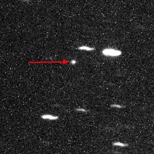Black and white image of a star field with one bright object in the center, indicated by a red arrow, believed to be the third interstellar object detected passing through our solar system.