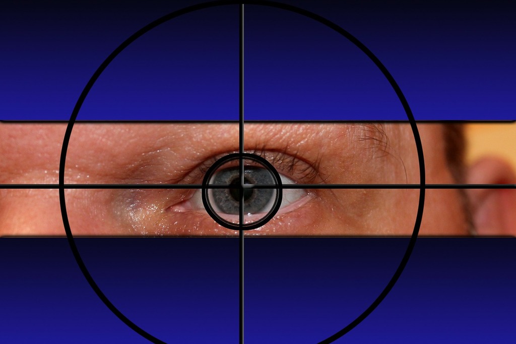 A close-up of a person's eye with crosshairs centered over the pupil, set against a blue background, illustrating the science of LASIK.