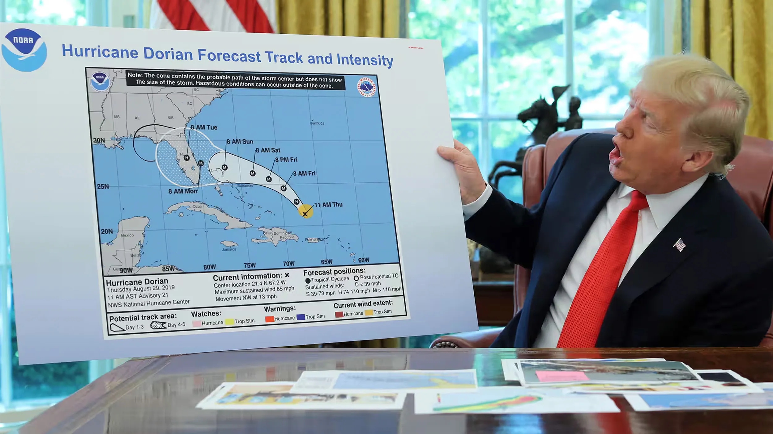 A person in a suit holds up a NOAA map showing the forecast track and intensity of Hurricane Dorian, reminding us that, unlike Einstein, we can't change the facts—only prepare for them—in an office setting.