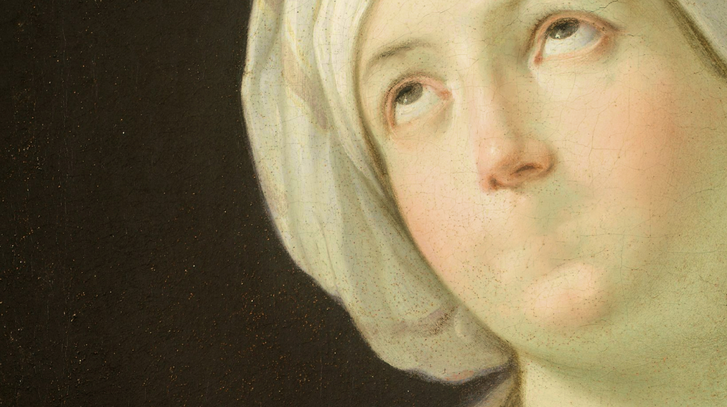 Close-up of a classical painting showing a woman in a white headscarf looking upward with her lips pressed together; background is dark.