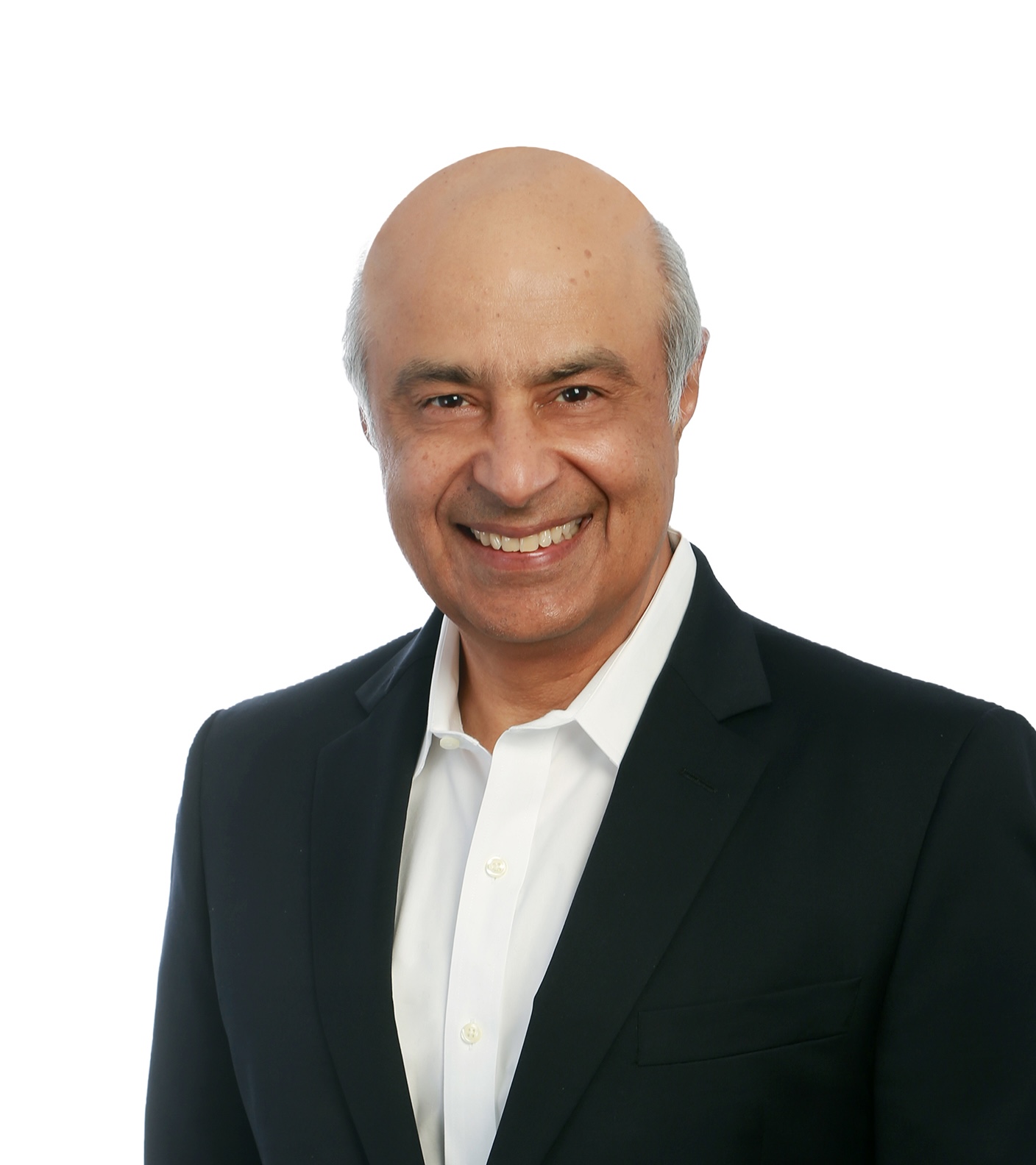 A middle-aged man with a shaved head and dark suit jacket smiles at the camera against a plain white background.