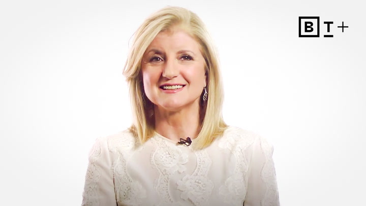 A woman with blonde hair wearing a white textured top smiles at the camera against a plain white background with a "BT+" logo in the top right corner.