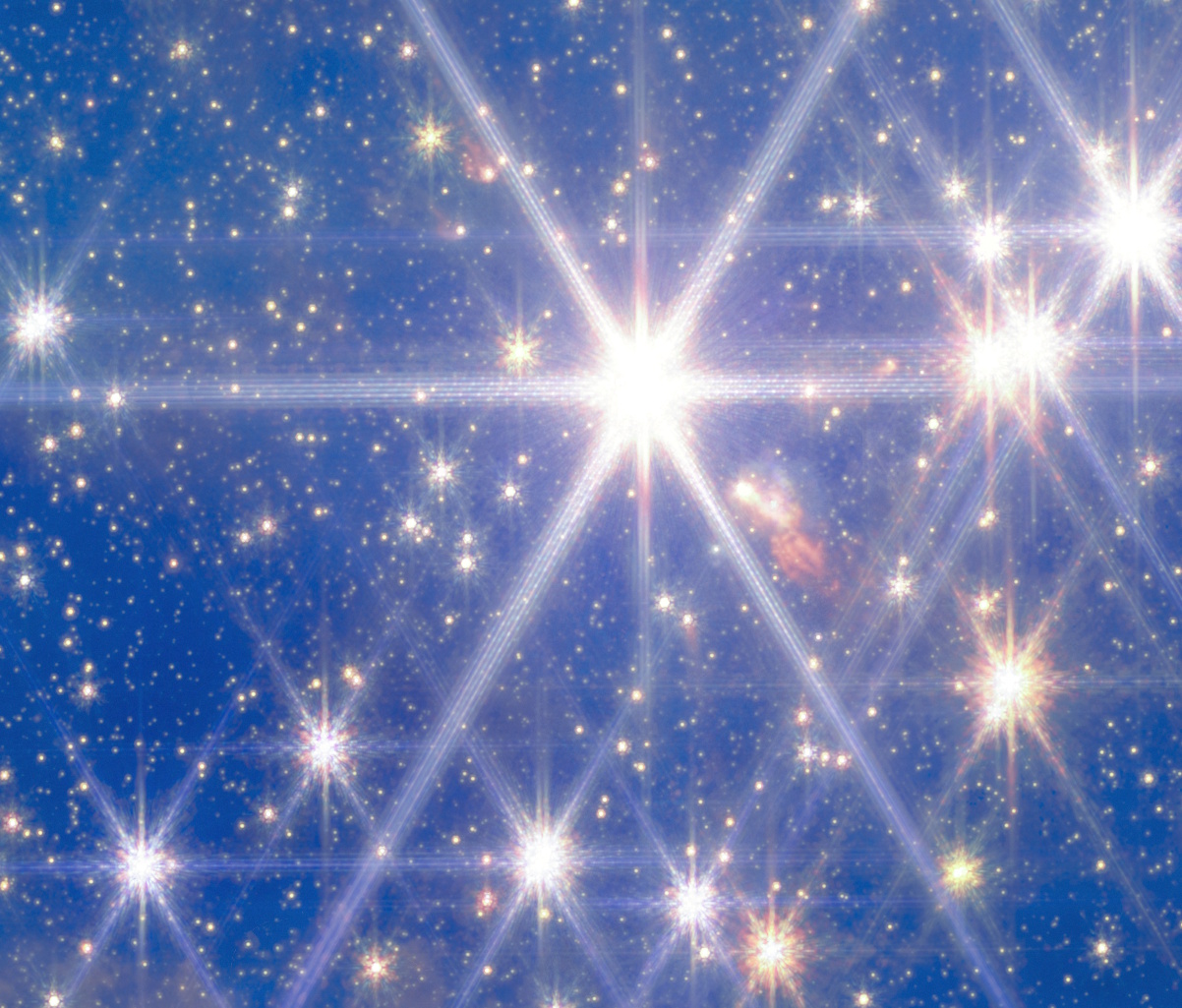 A dense field of bright stars, resembling Hubble or JWST images, shines against a deep blue background, with several stars displaying prominent diffraction spikes&mdash;evoking the splendor of clusters like Pismis 24.