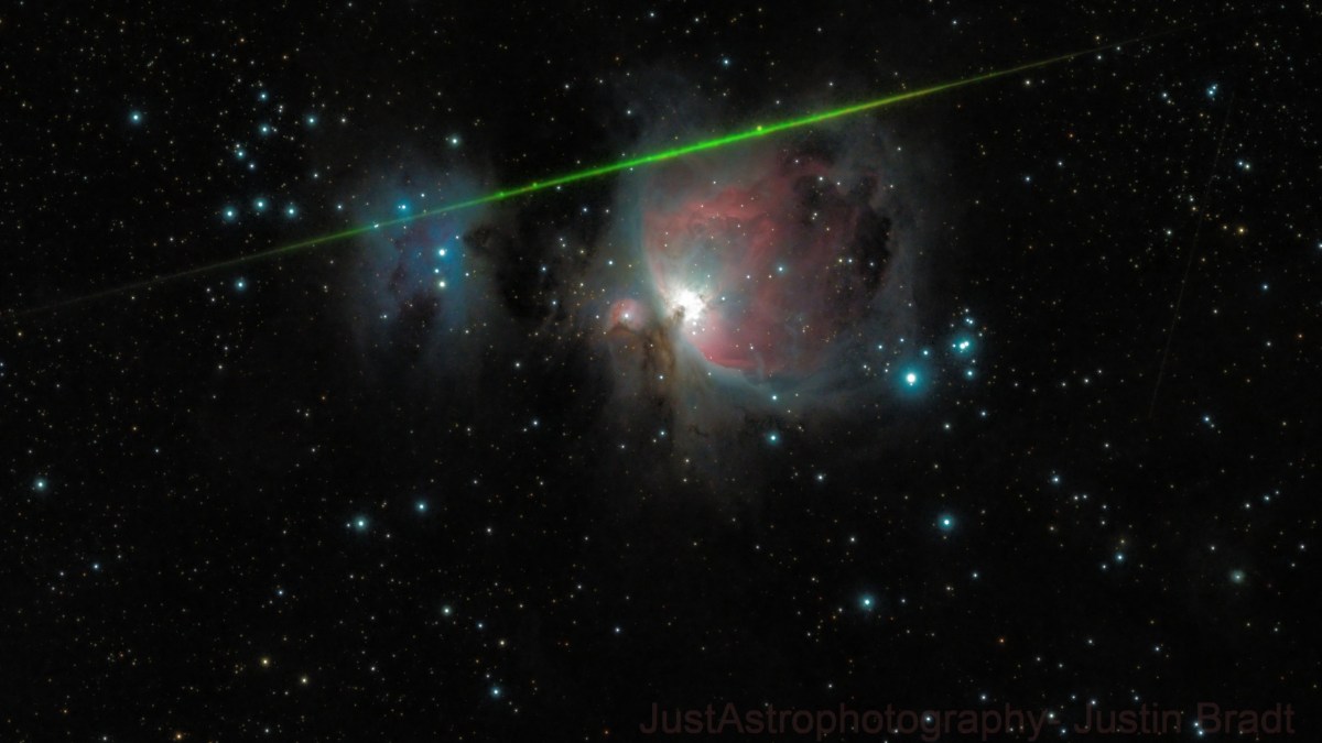 The Orion Nebula surrounded by stars, with a bright green meteor streaking diagonally across the image, evokes the wonder of shooting stars illuminating the night sky.