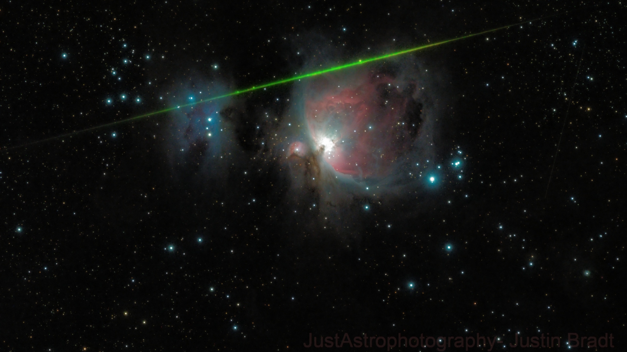 The Orion Nebula surrounded by stars, with a bright green meteor streaking diagonally across the image, evokes the wonder of shooting stars illuminating the night sky.
