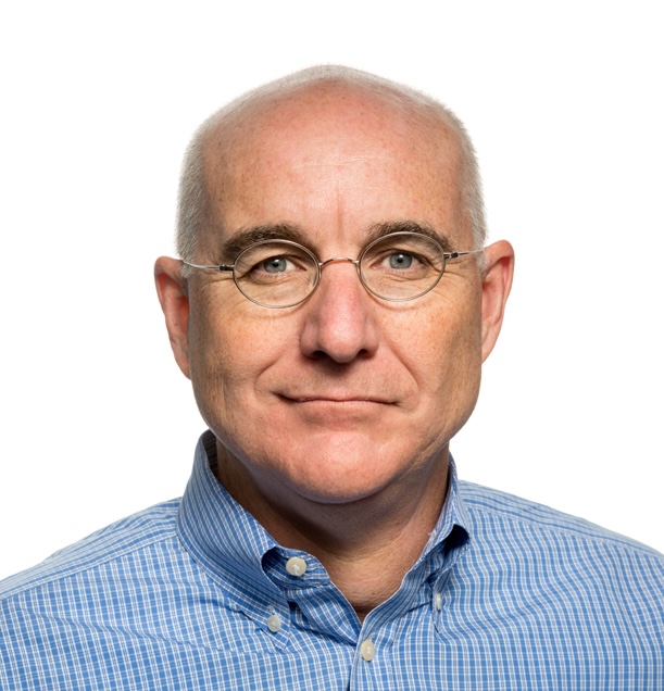 A middle-aged man with glasses, light skin, and a bald head, wearing a blue checkered shirt, facing forward against a white background.