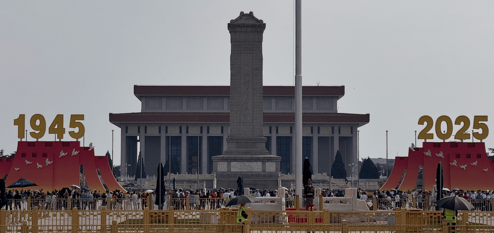 Crowds gather in front of the Monument to the People's Heroes and Mao Zedong Mausoleum in Tiananmen Square, China, with large "1945" and "2025" signs displayed on either side.