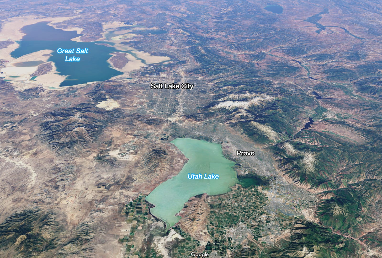 Aerial view showing Great Salt Lake, Salt Lake City, Utah Lake, and Provo, with landscape and labeled locations.