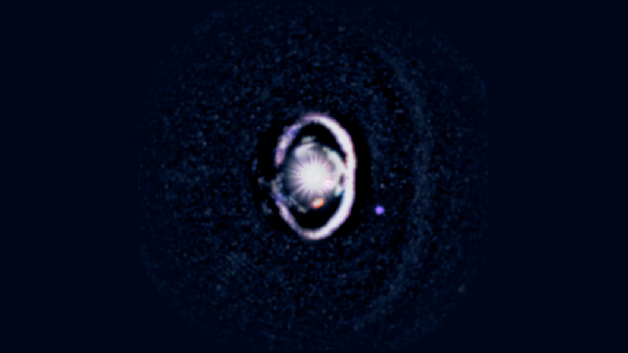 A bright, circular object with concentric rings and a surrounding halo set against a dark background, resembling a gap-clearing planet or other astronomical phenomena.