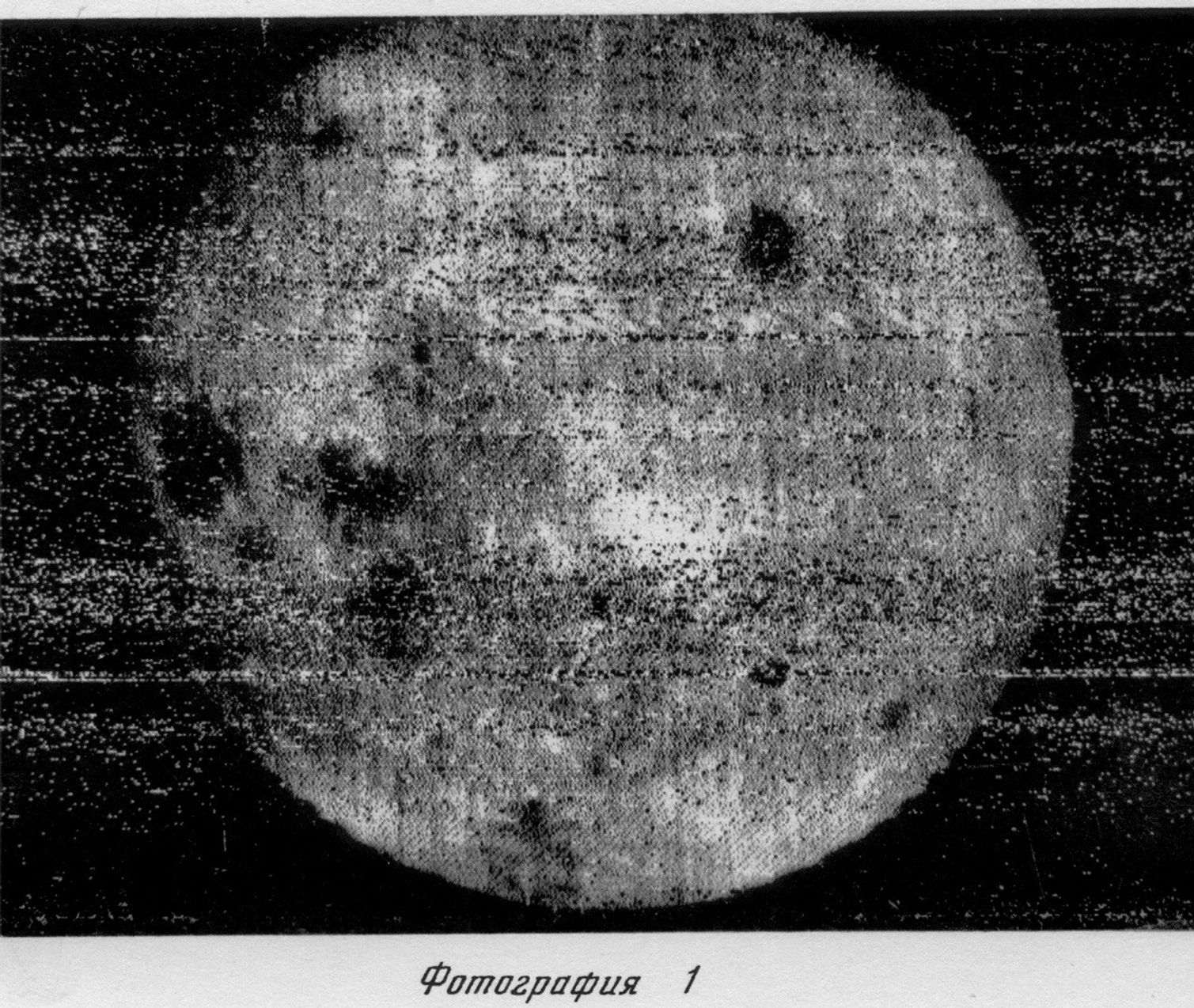 Black and white, grainy image of the Moon&rsquo;s surface with visible craters, possibly from the dark side moon, and text in Russian below the photo.