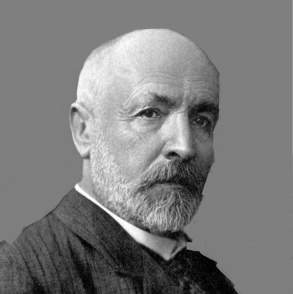 Black and white portrait of an older man with a bald head, gray beard, and mustache, wearing a suit and looking slightly to the side.