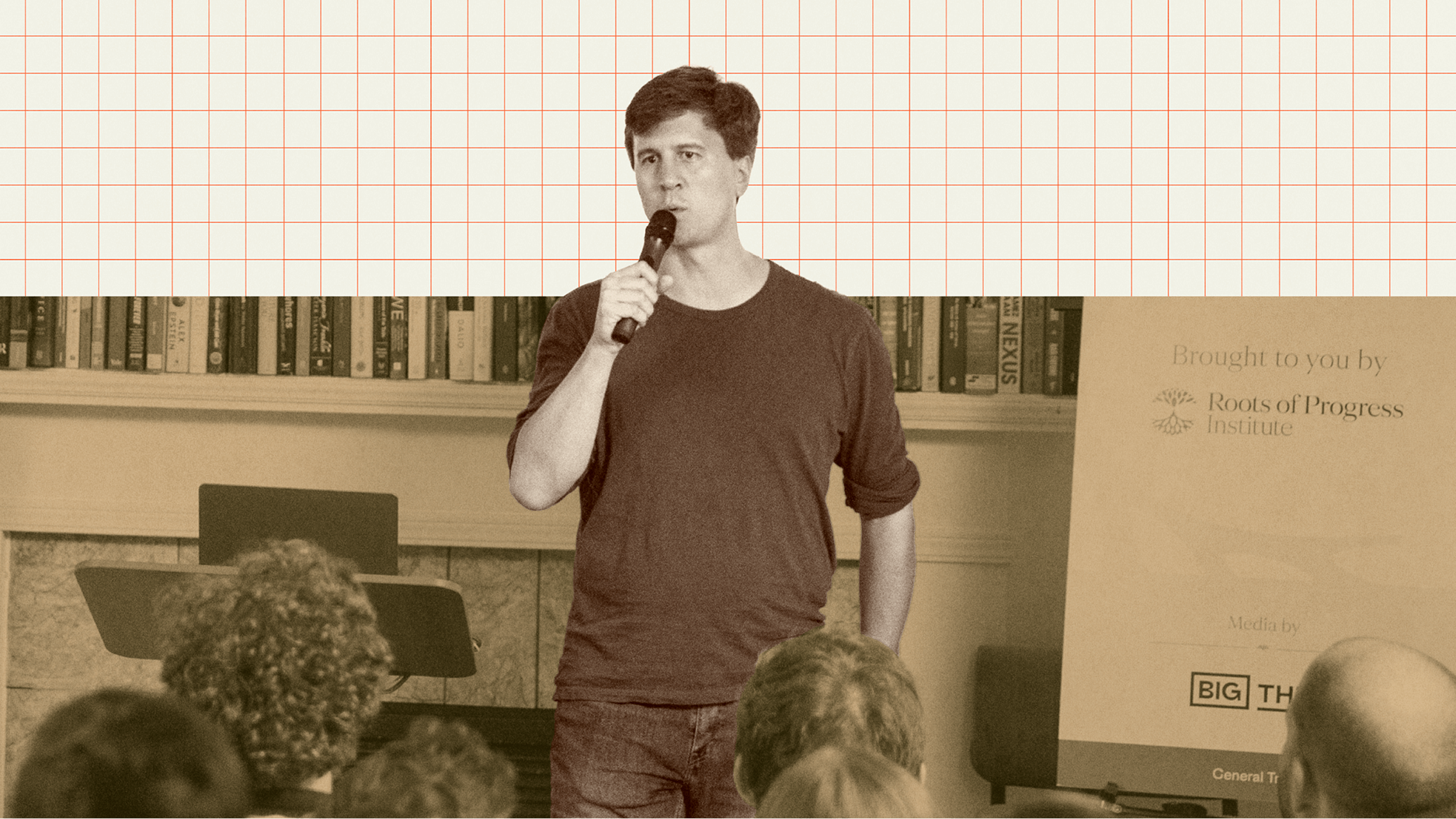 A man holding a microphone speaks to an audience in front of a bookshelf and a display with logos, including "Roots of Progress Institute" and "Big Think.