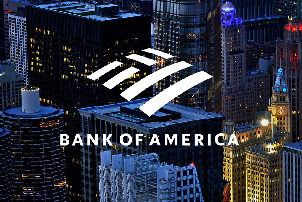 Bank of America logo overlaid on a nighttime cityscape with illuminated skyscrapers and office buildings.