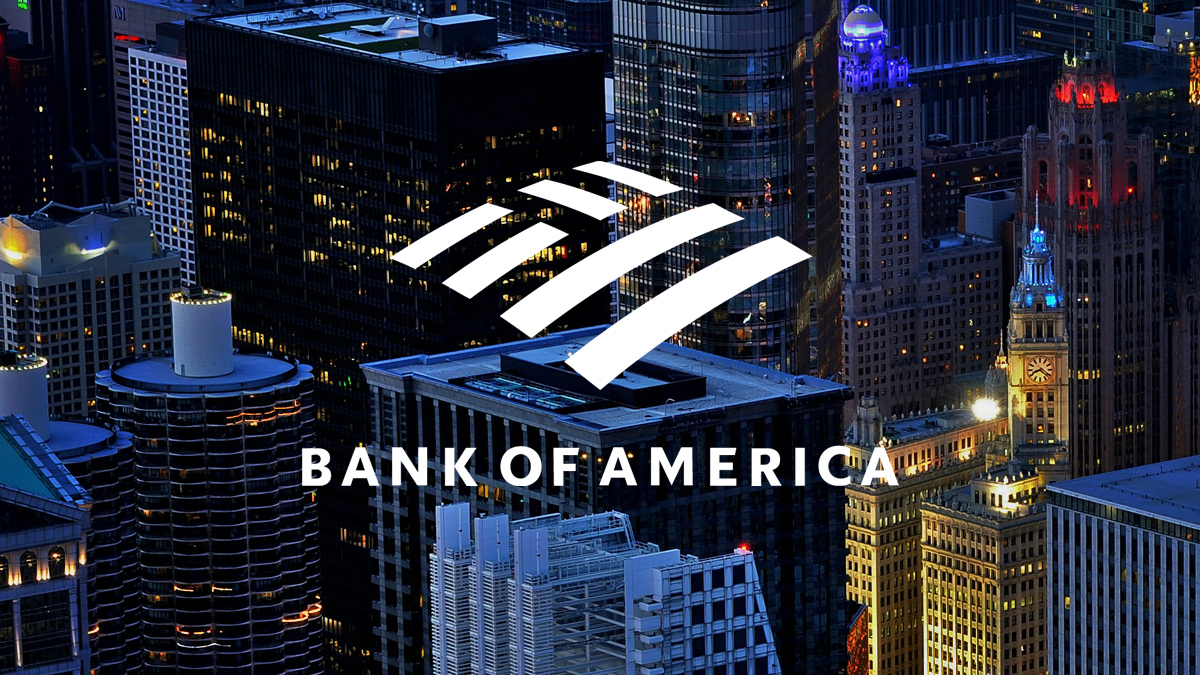 Bank of America logo displayed over a nighttime cityscape with tall, illuminated office buildings and skyscrapers.