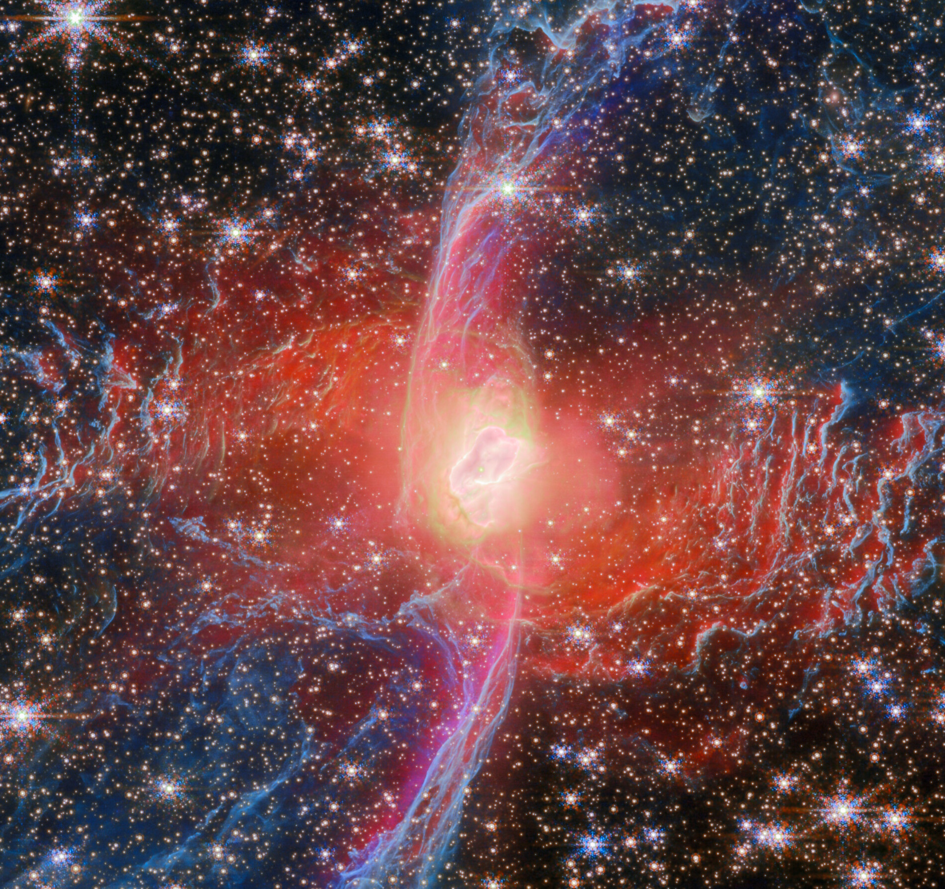 A nebula with bright central light, vivid red and blue gas clouds, and numerous surrounding stars in deep space.