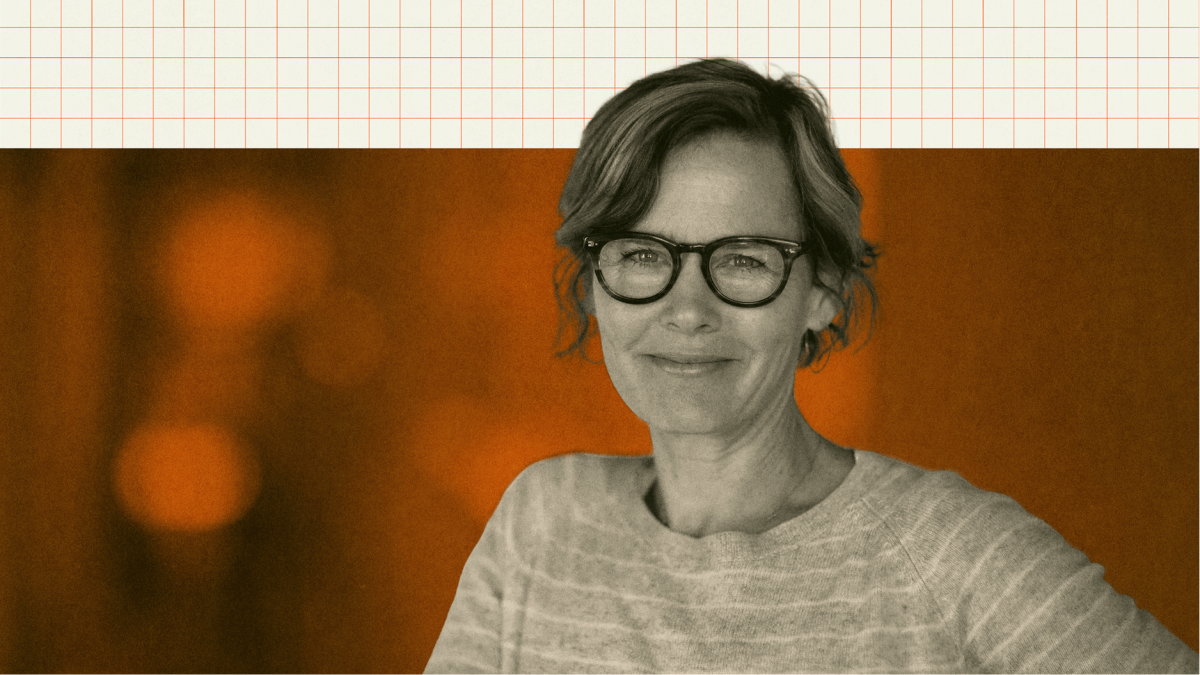 A woman with glasses and short hair smiles slightly, wearing a striped sweater, with an orange-toned background and a grid pattern above.