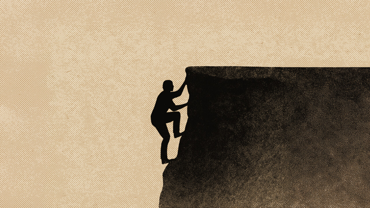 A silhouette of a person climbing up the edge of a steep cliff against a beige background.