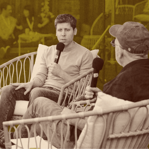 Two people sit in wicker chairs outdoors, holding microphones and having a conversation about energy abundance. Other people are visible in the blurred background.