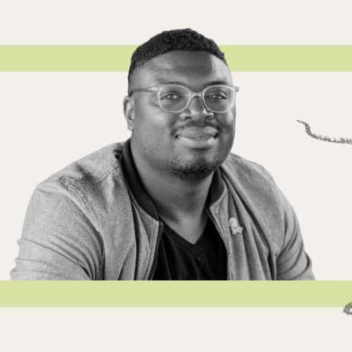 A man wearing glasses and a jacket looks at the camera, seated in front of a light background with a green rectangular frame and gray squiggle lines.