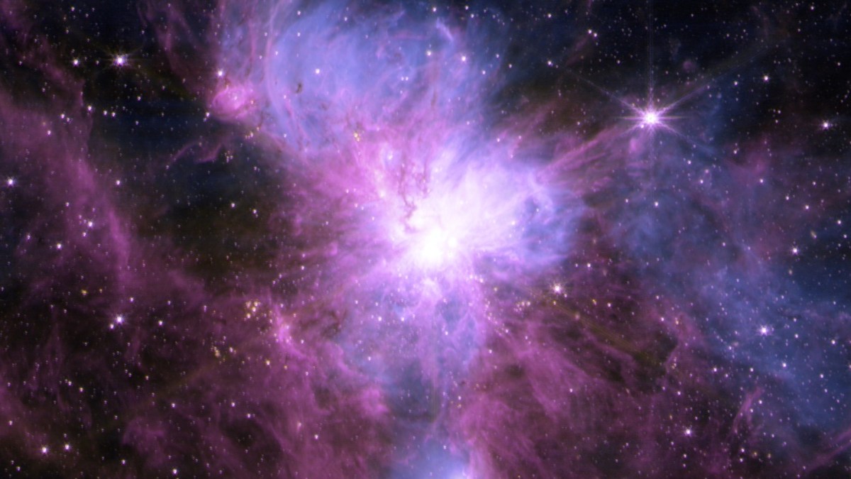 A nebula in space glows with bright purple, pink, and blue hues, surrounded by stars and cosmic dust where new stars form in our expanding universe.