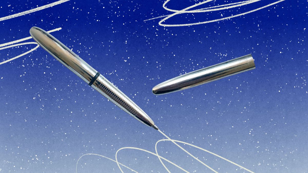 A silver space pen with its cap removed appears to write swirling white lines against a blue, starry background.