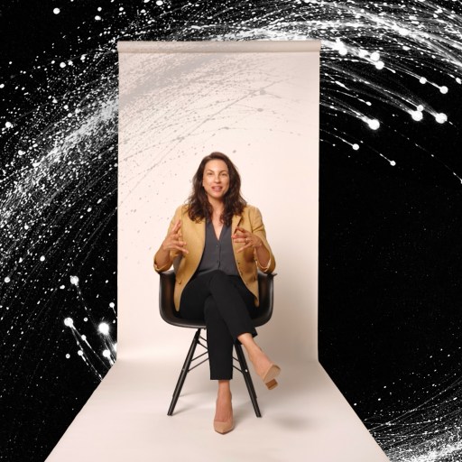 A woman sits on a chair against a white backdrop, gesturing with her hands, with a dynamic black background and white abstract swirl surrounding her.