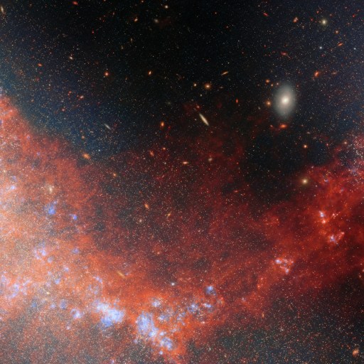 A vivid image of a galaxy with bright blue and red nebulous clouds, set against a black star-filled background in deep space.