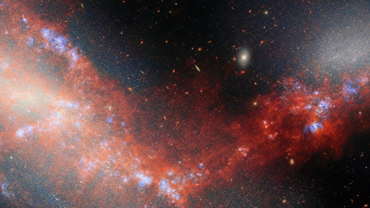 A vivid image of a galaxy with bright blue and red nebulous clouds, set against a black star-filled background in deep space.