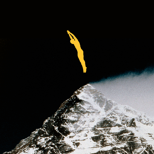 A yellow silhouette of a person dives above the snow-covered peak of a mountain against a dark sky.