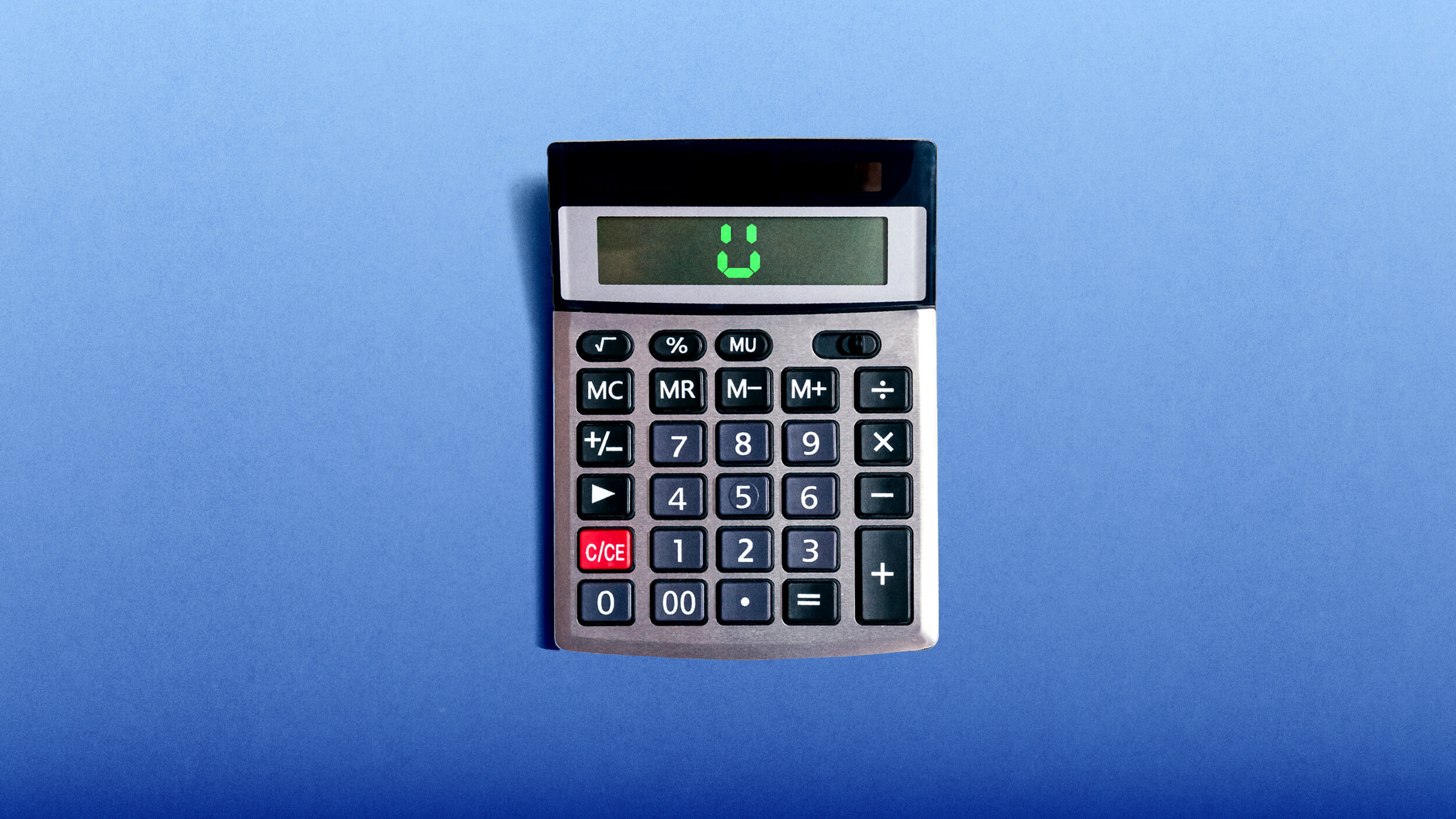 A calculator on a blue surface displays a smiling face on its screen.