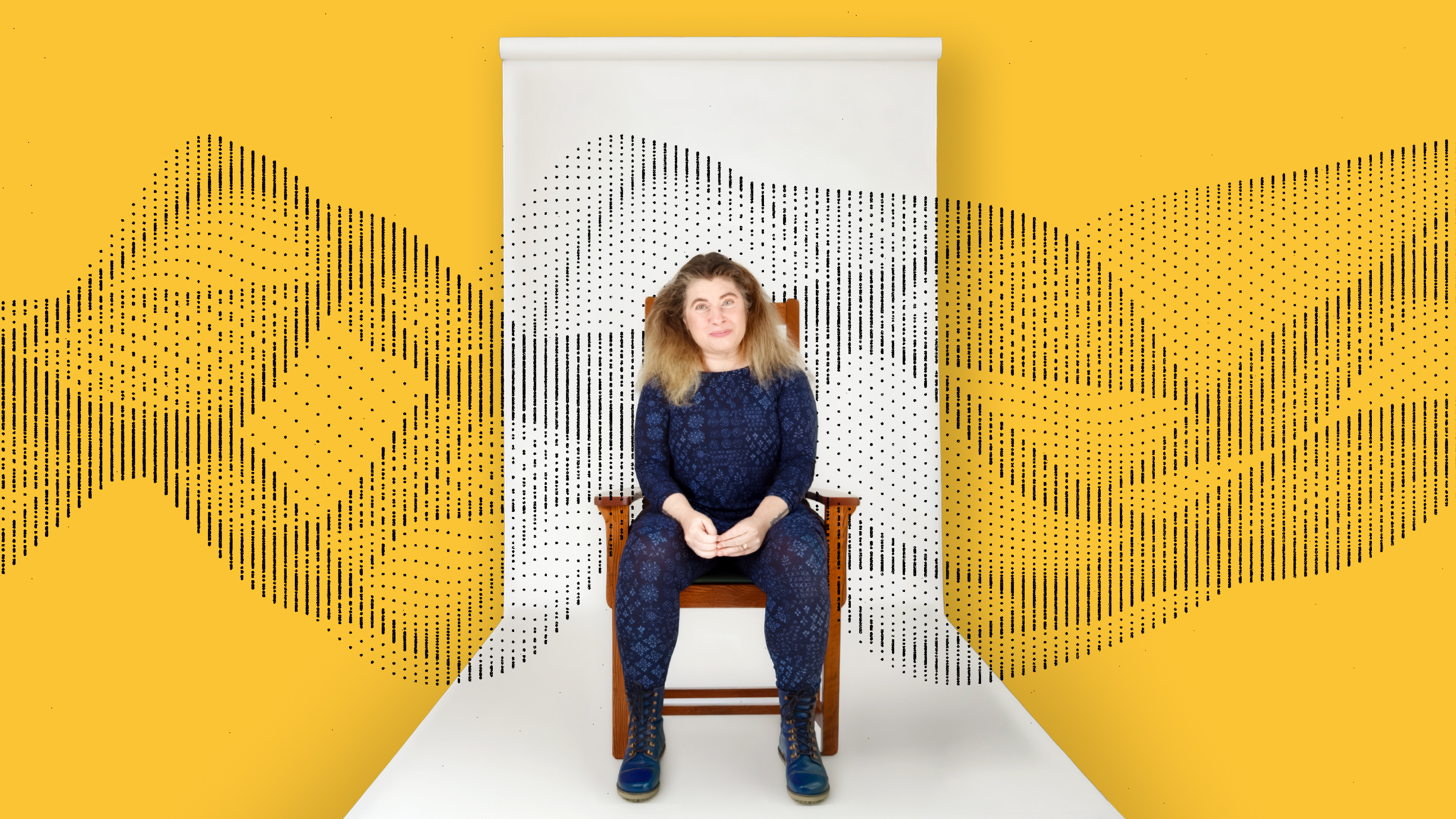 A person sits on a chair against a white backdrop with abstract black dotted patterns, set against a yellow background.