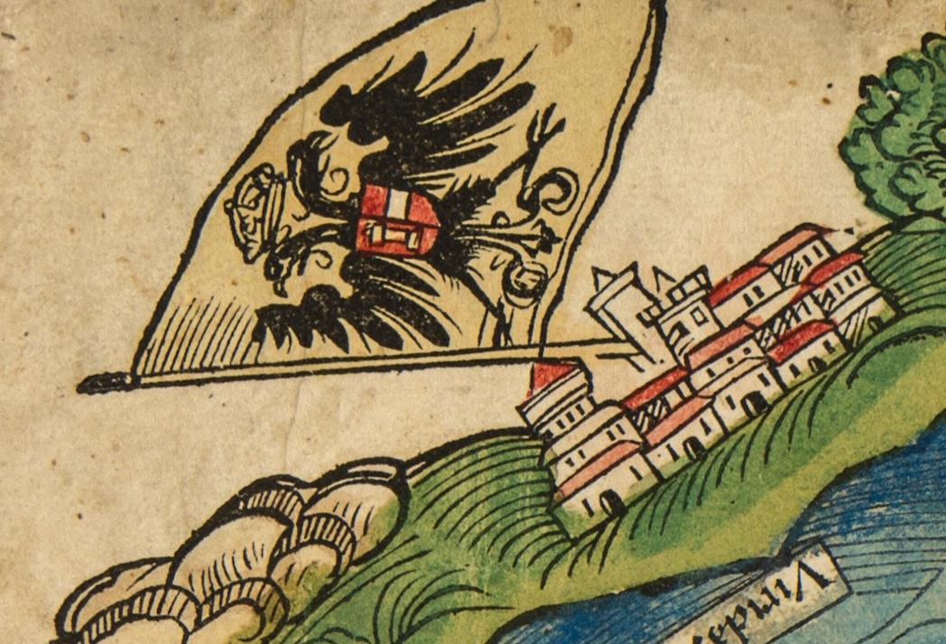 A medieval illustration of a black double-headed eagle crest on a flag next to a cluster of buildings, likely representing a historic European city or settlement.