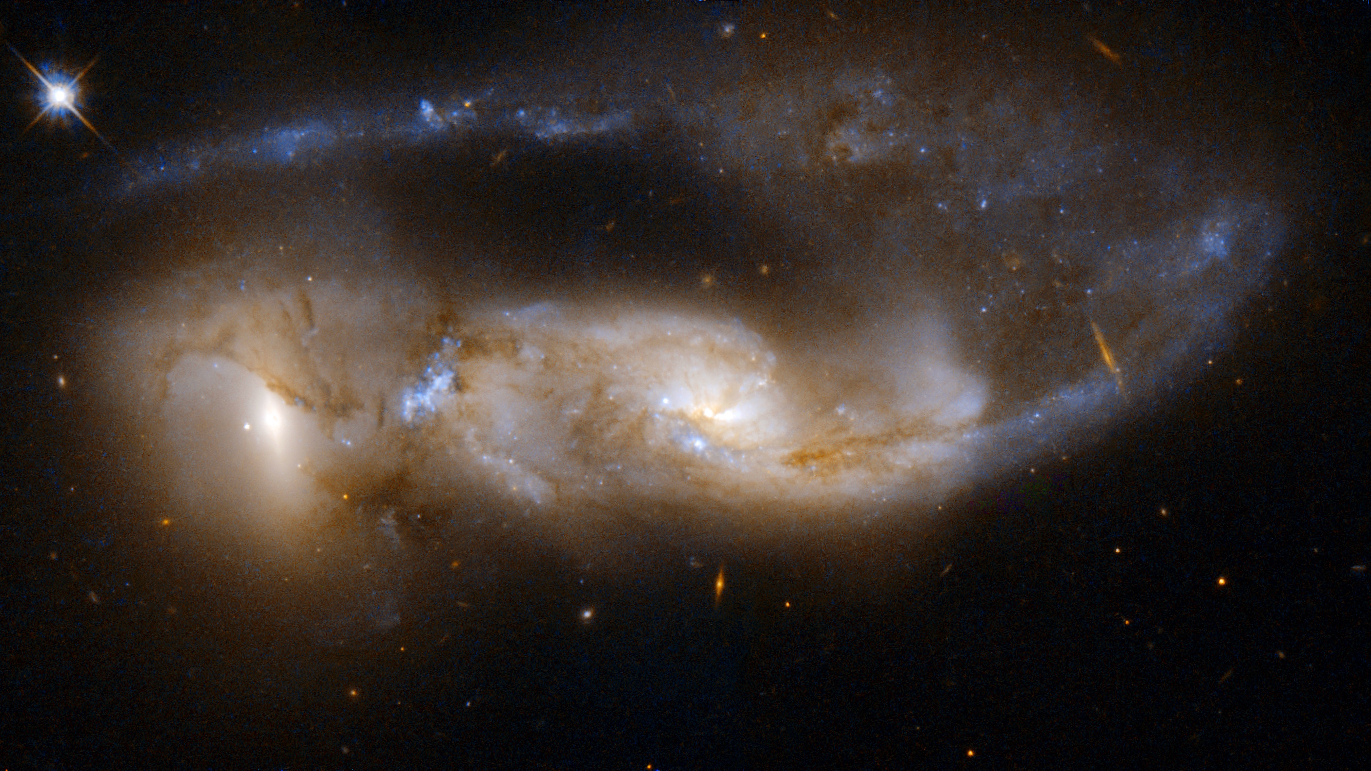 Two peculiar galaxies collide in deep space, forming bright clusters and swirling dust clouds—a striking scene that reveals the beauty and violence of the cosmos against a dark background.