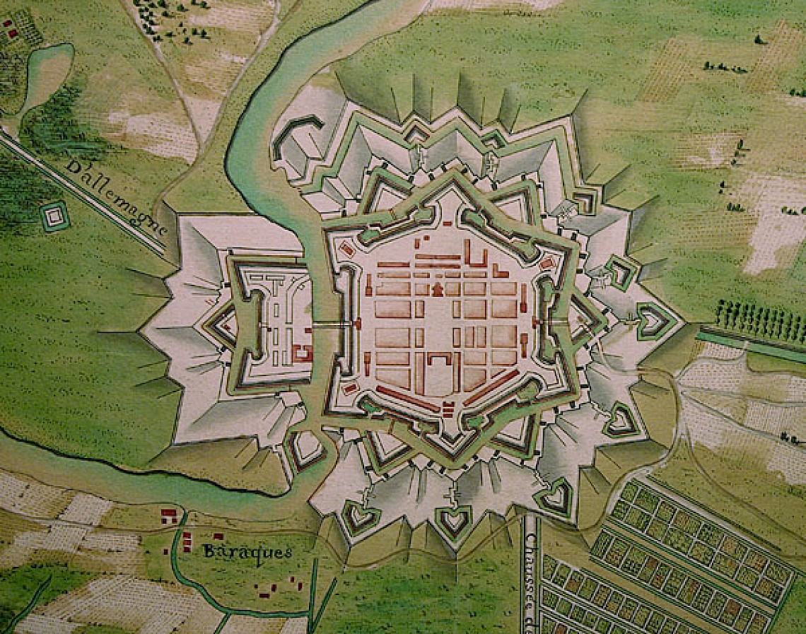 Historic map illustration of a star-shaped fortified city with surrounding moat, labeled roads, and buildings visible outside the city walls.