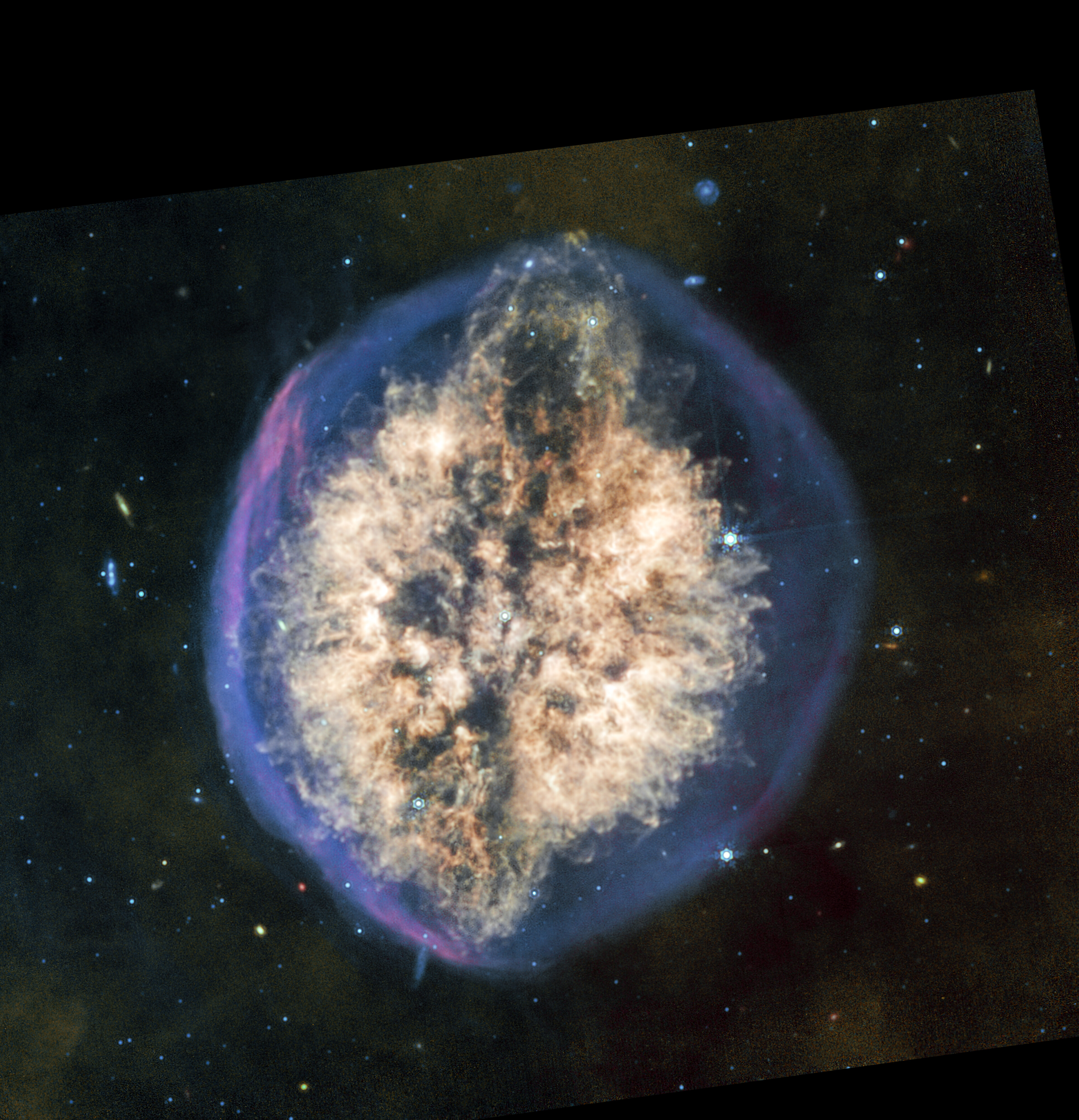 A detailed image of a nebula in space shows a bright, cloud-like structure surrounded by a faint, glowing outer shell against a star-filled background.