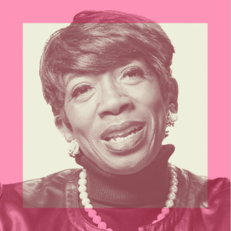 Portrait of a smiling woman with short hair, wearing a pearl necklace, earrings, and a dark top, against a pink and cream background.