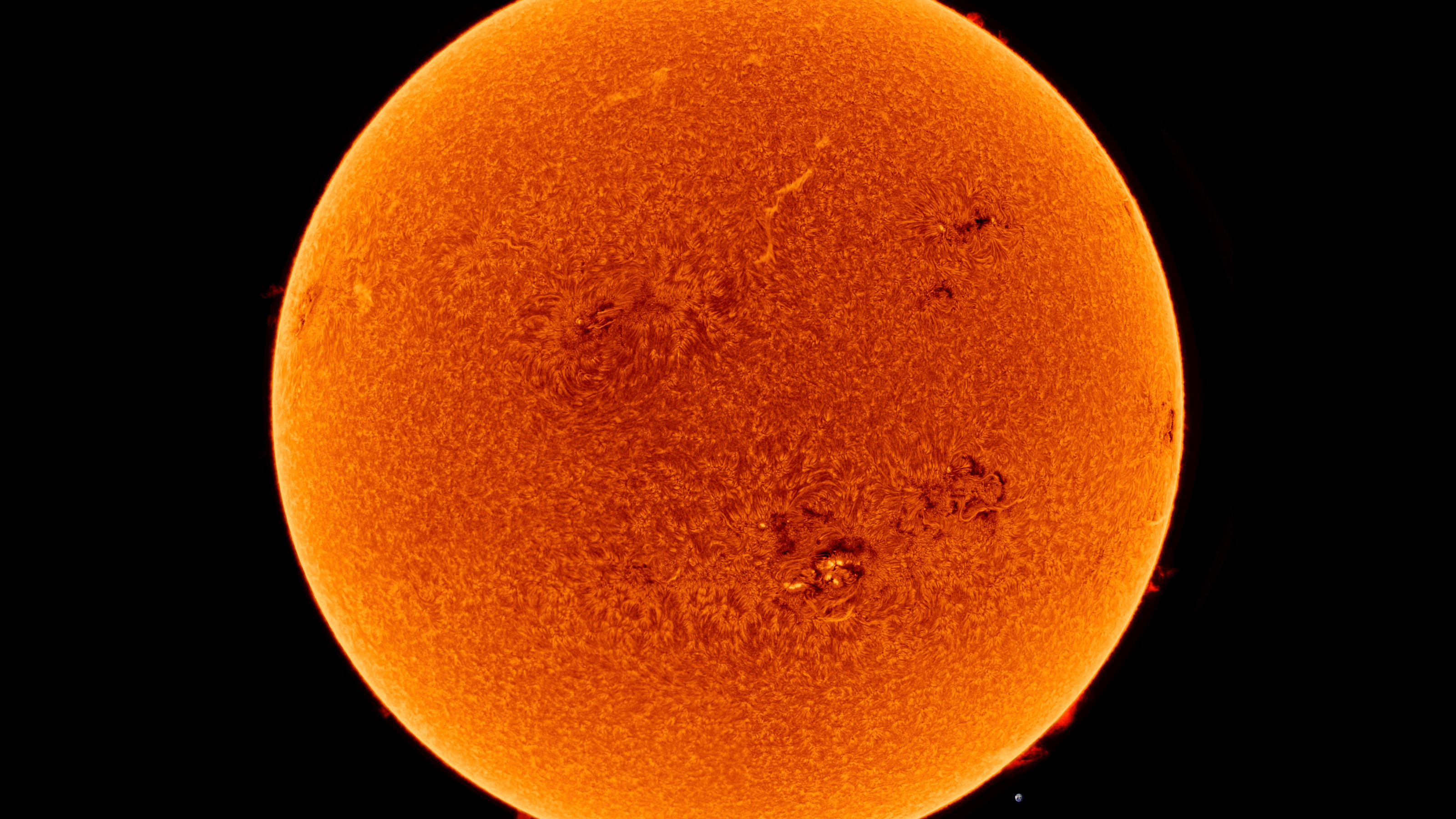 A detailed orange image of the Sun shows its surface texture and sunspots, against a black background.