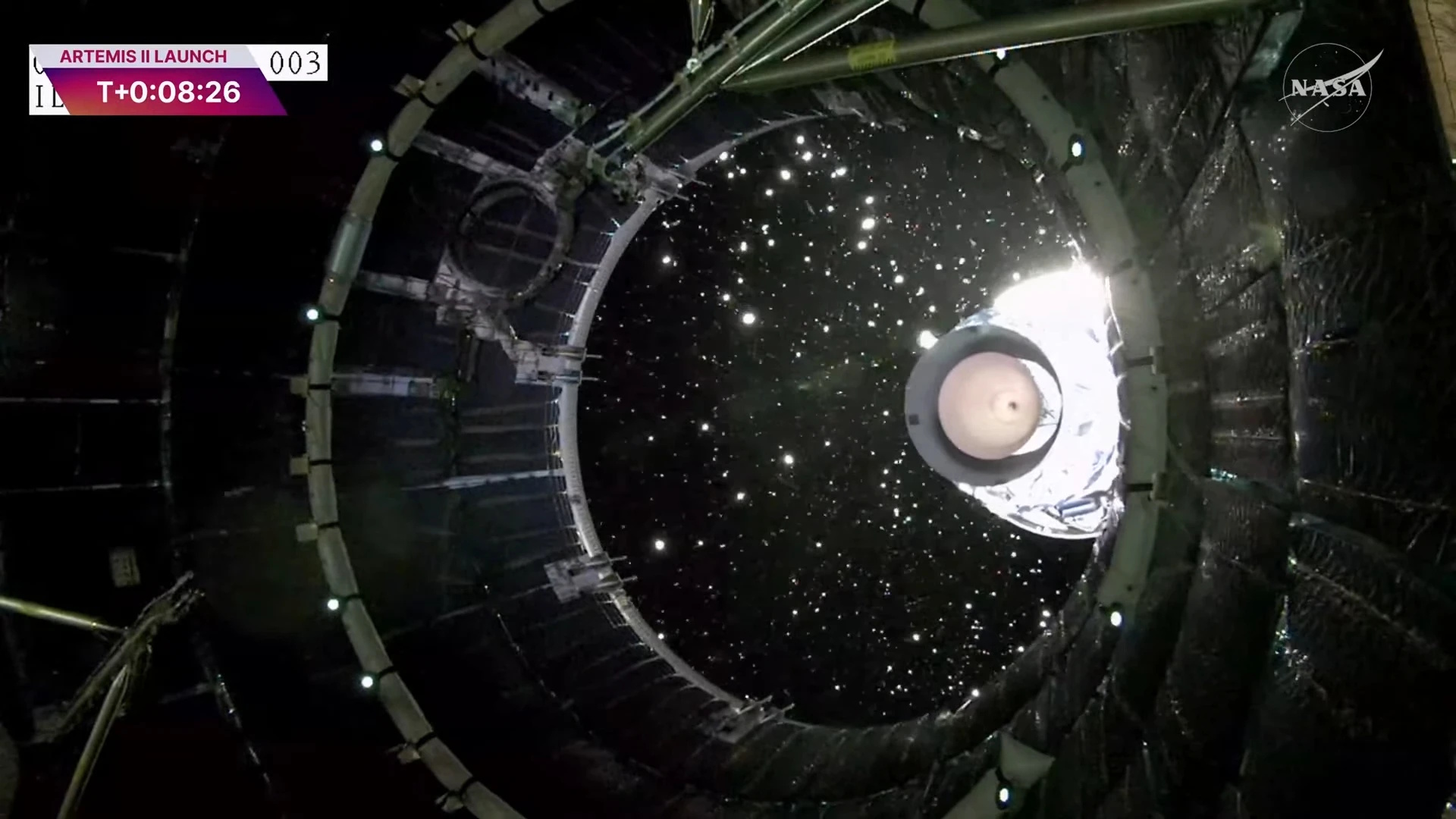 View from inside a spacecraft showing stage separation during the Artemis I launch, with debris and stars shining against space&rsquo;s blackness. The NASA logo and launch timer are displayed, capturing the hope of Artemis II's journey to the Moon and back to Earth.