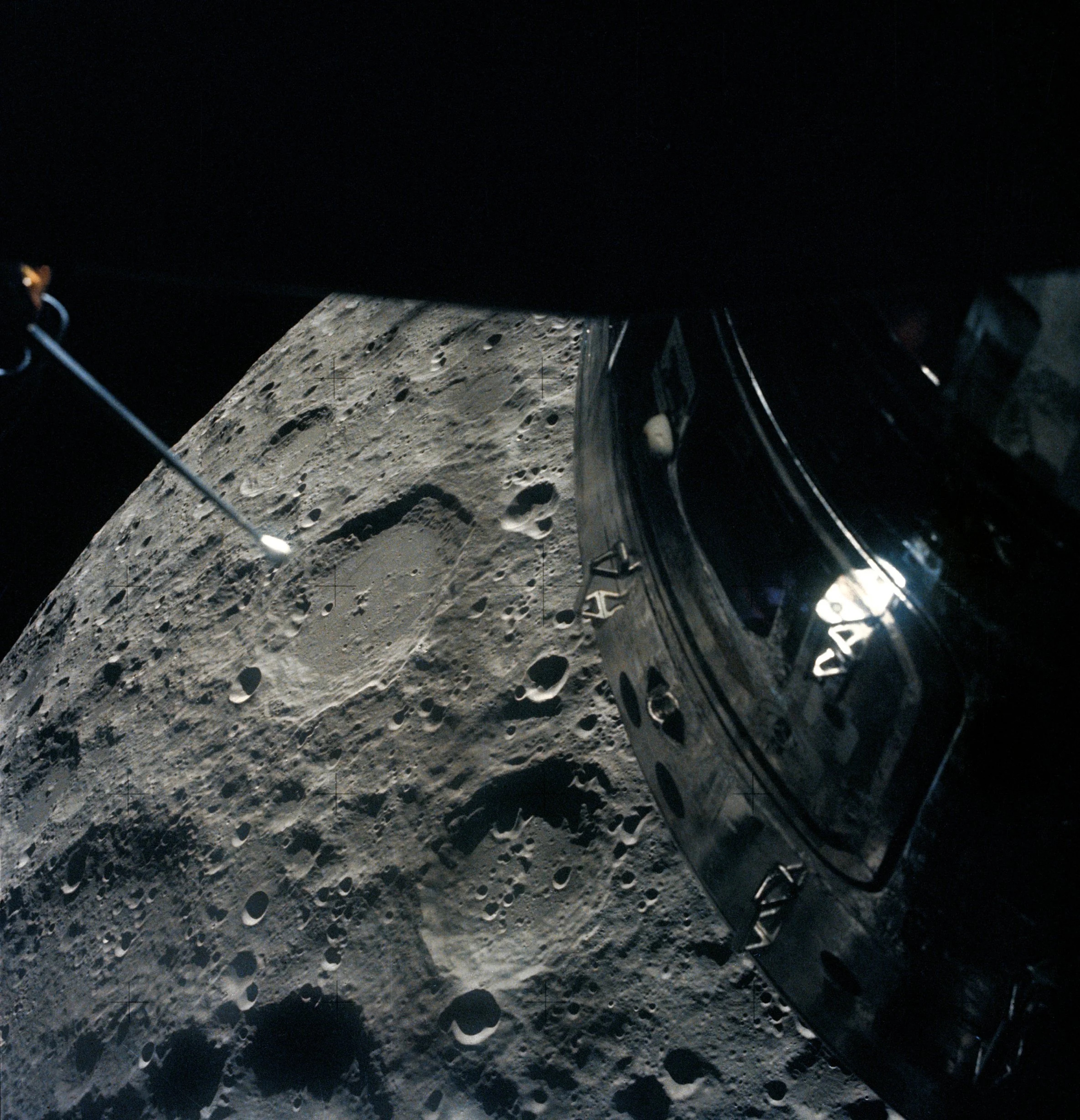 Close-up view of a spacecraft module orbiting above the moon&rsquo;s cratered surface, with part of an instrument visible extending outward&mdash;capturing the moment as Artemis II aims for a new distance record.